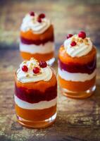 Three dessert cups with whipped cream and cranberries photo