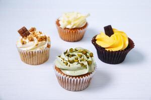 A group of four cupcakes on a white table photo