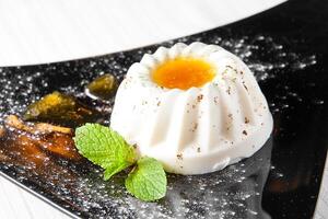 A dessert with an egg on top and some mint leaves photo