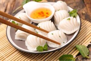 Chopsticks and dumplings on a plate with sauce photo
