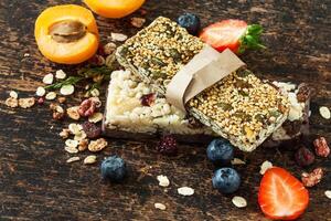 Granola bars with fruit and nuts on a wooden table photo