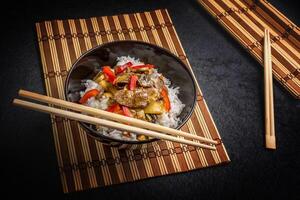 Chopsticks and rice in a bowl with chopsticks photo