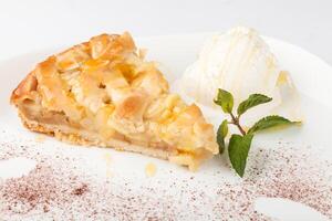 A slice of pie on a white plate with a scoop of ice cream photo