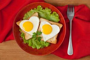 A plate with two eggs and toast in the shape of a heart photo