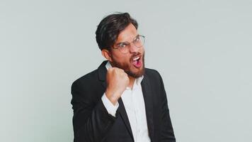 Aggressive angry Indian businessman trying to fight at camera, shaking fist, boxing with expression, punishment, threaten, bullying, abuse, mad fury. Arabian man guy isolated on gray studio background video