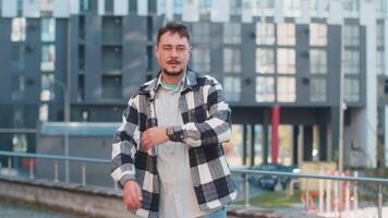 Portrait of smiling Caucasian mature man turning looking at camera, resting, relaxation feel satisfied glad expression of good news outdoors. Bearded tourist on urban city street. Town lifestyles. video