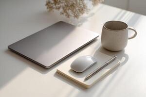Modern Minimalist Workspace Setup Laptop, Notebook, and Cozy Mug on a Clean White Desk. Perfect for Productivity and a Serene Work from Home Atmosphere. photo