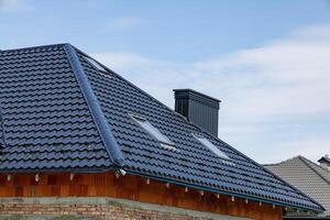 New roof with metallic tiles and skylights enhances the modern design of the home while providing durability and style photo