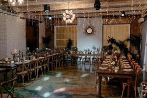 Elegant rustic wedding venue with long tables and warm lighting photo