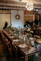 Rustic wedding reception table setting with floral decor and wooden chairs photo