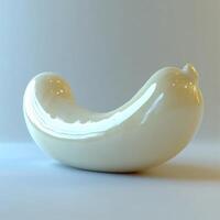 Smooth white ceramic figurine shaped like a banana resting on a plain background photo
