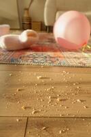 Messy aftermath of a party with pink balloon in living room photo