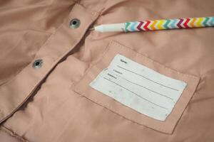 A label on soft pink fabric displays spaces for name and comments photo