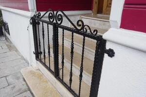Decorative black gate at entrance of a charming home photo