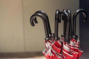 Red closed folding umbrellas with black plastic handles. photo
