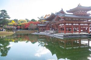 Byodo-in Temple Uji Kyoto Japan, Serene temple reflection on a tranquil pond in autumn scenery. photo