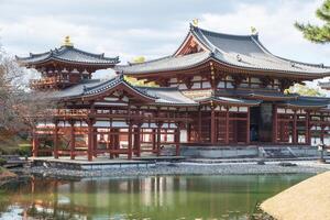 Byodo-in Temple Uji Kyoto Japan, Historic Japanese temple by a serene pond surrounded by nature. photo