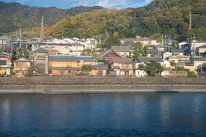 Scenic riverside view with traditional homes and lush greenery in Uji, Kyoto. photo
