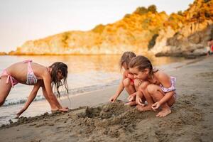 Family enjoying quality time building sandcastles at the beach photo