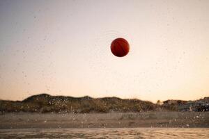 Family enjoys an adventurous game of basketball by the beach at sunset photo