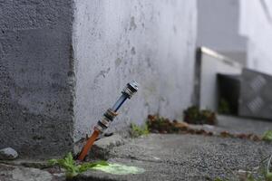 Fiber optic connection is installed between the footpath at paving stones and the house wall photo
