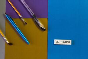 Stationery and a sign saying September are on the colored cardboard. Concept of learning photo