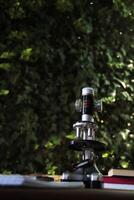 Microscope on a desk with nature background photo