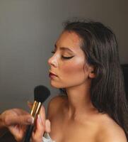 Confident model wearing bright lipstick and golden earrings. The simple background keeps the focus on her photo