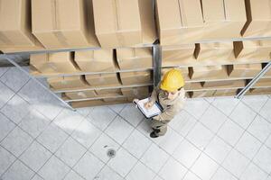 Female employee examining cargo on shelves for efficient distribution, managing the shipment process, inventory control, and packaging of goods for import export delivery service. photo