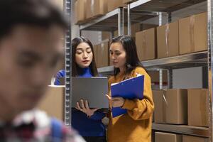Female employees in a small scale depot preparing packages with custom orders, ensuring local shipment for the small business development. In house express delivery in warehouse. photo