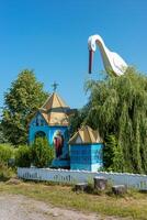 Unique chapel with a stork and well is found in Teresva, Transcarpathia surrounded by greenery photo