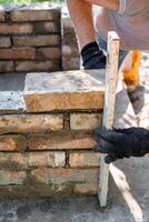 Closeup of leveling bricks during construction of brick structure using spirit level photo