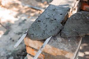 application wet cement on brick structure showing texture and process of barbecue construction. photo
