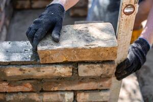 of leveling bricks during construction of brick structure using spirit level. photo