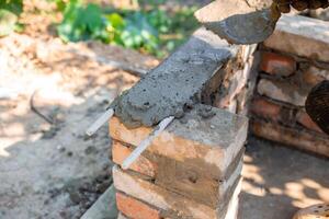 application of wet cement on brick structure showing texture and process barbecue construction, photo