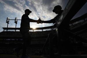 Detroit Tigers starting pitcher Tarik Skubal (left) greets  third base coach Joey Cora as he walks into the dugout after hit pre-game warmup before their game against the Seattle Mariners at Comerica Park. editorial_image