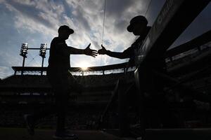 Detroit Tigers starting pitcher Tarik Skubal (left) greets  third base coach Joey Cora as he walks into the dugout after hit pre-game warmup before their game against the Seattle Mariners at Comerica Park. editorial_image