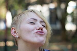 Youthful Girl Smiles Joyfully in a Park During a Sunny Afternoon photo