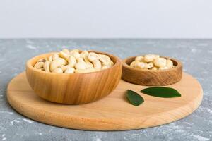 cashew nuts in wooden bowl on table background. top view. Space for text photo