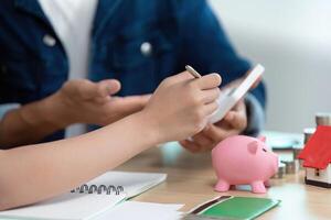 Financial Planning and Budgeting. A couple discussing savings strategies with a piggy bank and calculator. photo