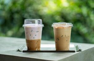 Close up glass of ice coffee with taro milk and ice cappucino on raw cement table of a coffee shop summer terrace. photo