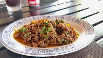 A vibrant minced chicken dish garnished with herbs, captured in natural light on a dining table in Phuket video