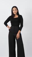 Elegant fashion model in a chic black outfit poses confidently in a studio photo