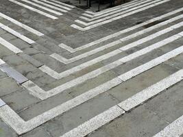 Abstract geometric pattern on gray stone pavement with white lines photo