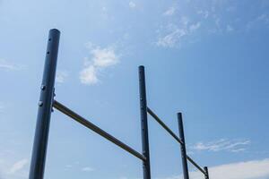 Parallel horizontal bars stand under a bright sky, providing a space for athletes to engage in strength training and gymnastics exercises photo