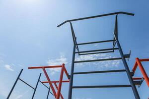 Parallel bars stand tall against a vibrant blue sky, creating a perfect spot for exercise and strength training for athletes and gymnasts photo