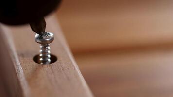 Detailed view of a screw being driven into wood using an electric drill, highlighting precision and craftsmanship video