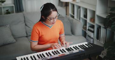 Handheld high angle view shot, A determined young woman is practicing her keyboard alone and enjoys a peaceful moment with music. video