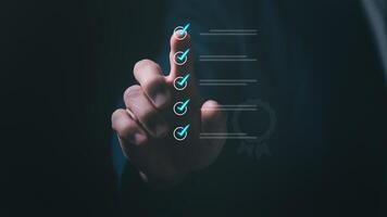Quality control and improvement to meet standards, a businessman pointing to a check mark in a box for a quality document control checklist and business project approval concept photo
