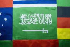 Saudi Flag Against a Multinational Flag Backdrop photo